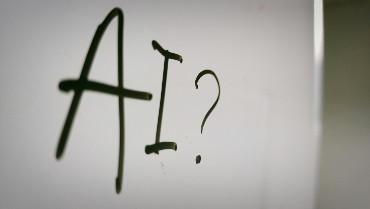 Handwritten text reading AI with a question mark